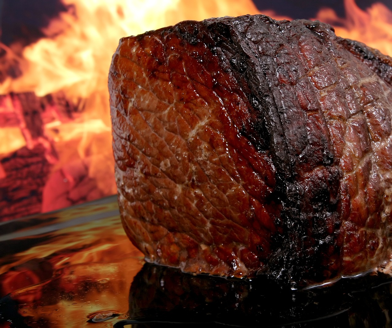 A large hunk of meat with flames behind it