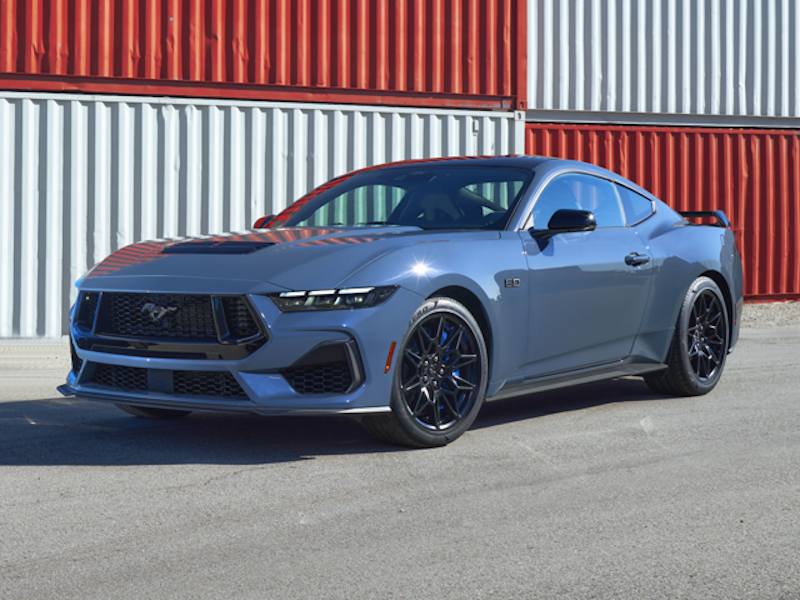 The 2024 Ford Mustang sitting in front of some shipping containers
